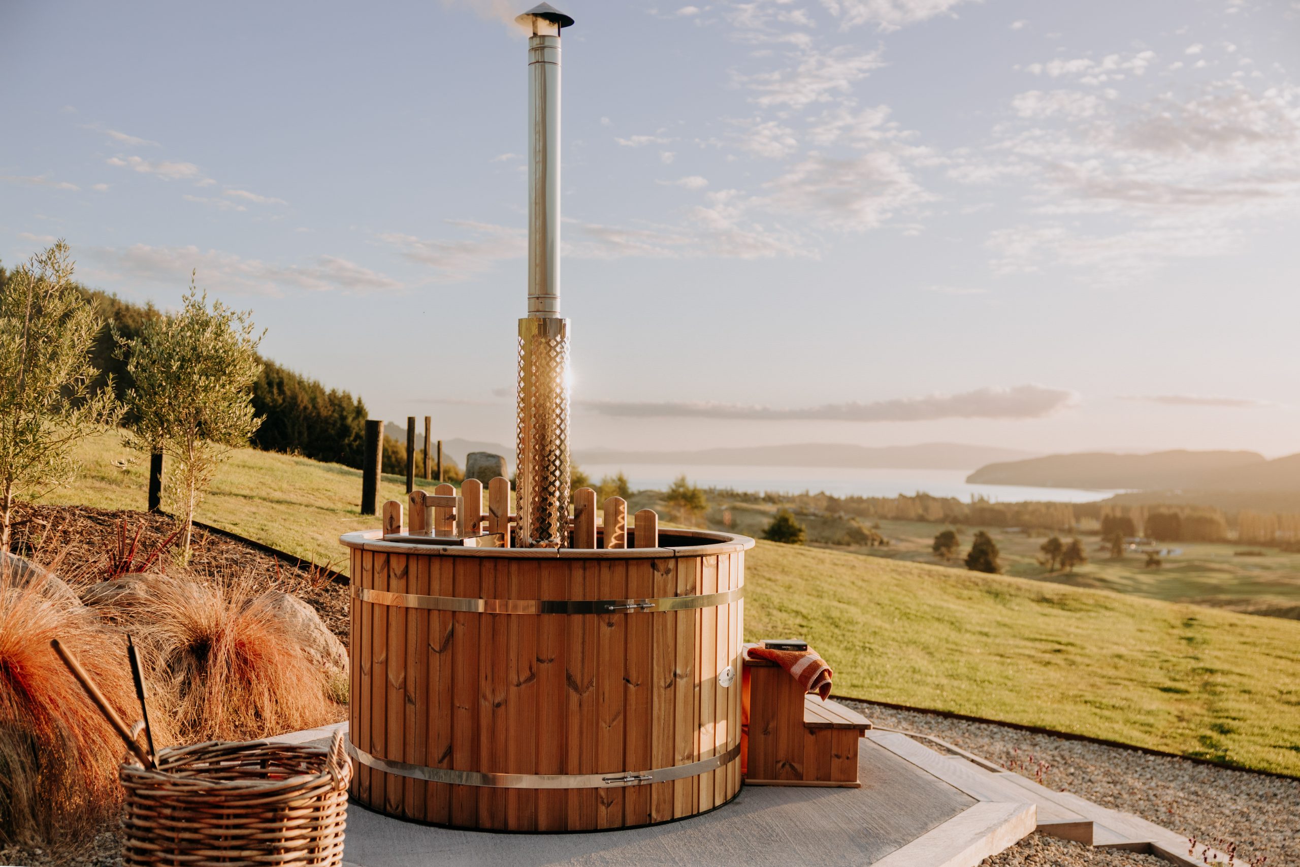 Wood-fired hot tub overlooking the lake at sunset